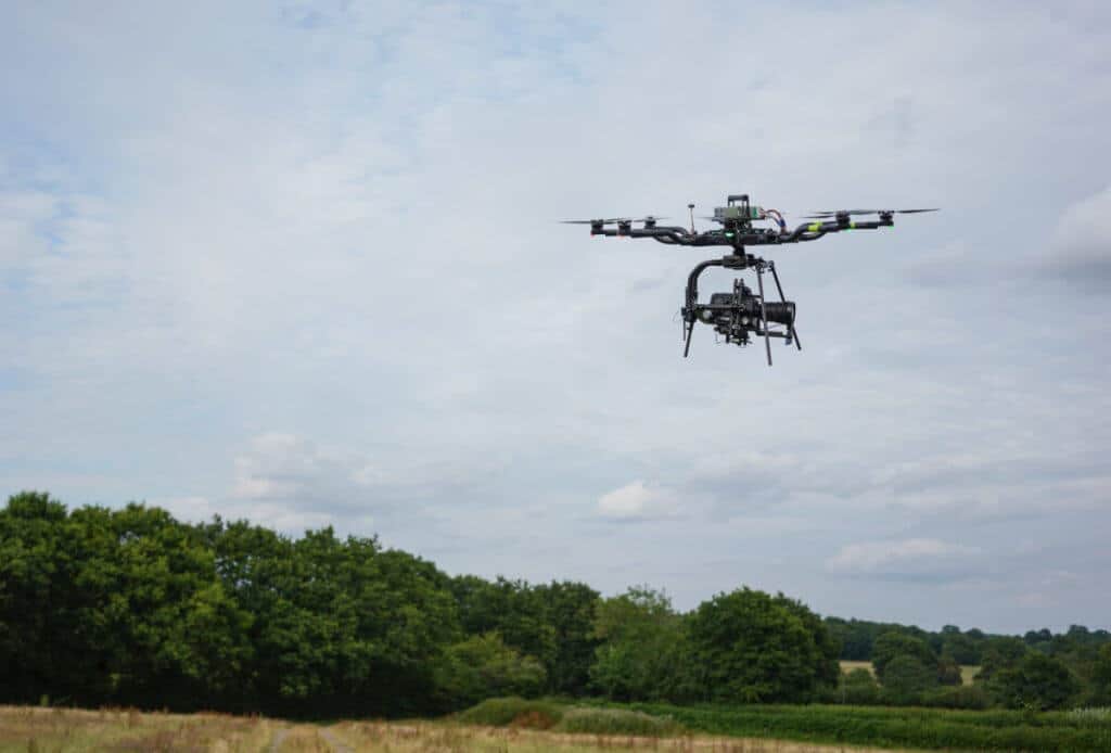A drone is photographed flying over the roof of the building