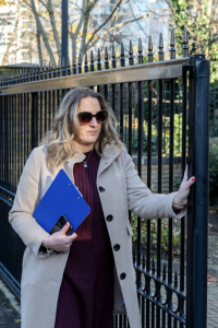 A property manager holds a clipboard whilst checking a gate for emergency access provision