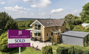 A house with a for sale board outside