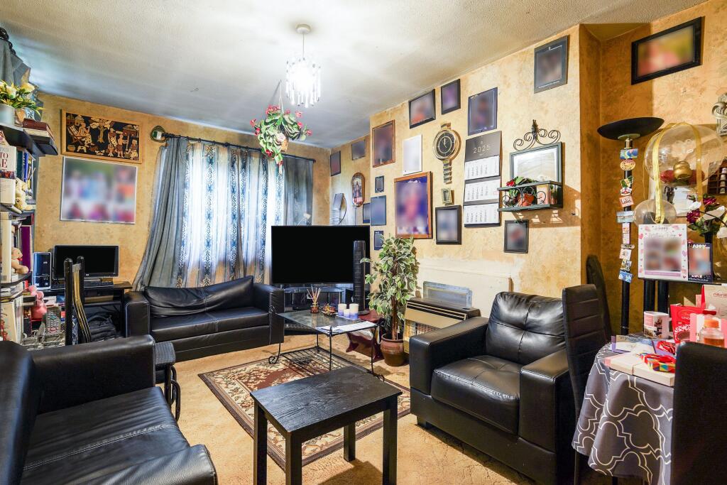 A dark yellow room with leather sofas and lots of images cluttered on the wall