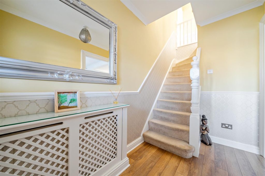 A cosy hallway with yellow walls and white woodwork.