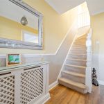A cosy hallway with yellow walls and white woodwork.