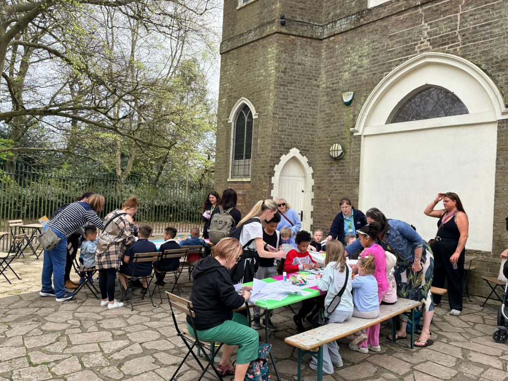 Families and event staff gathered around a set of crafting activities outside Severndroog Castle.