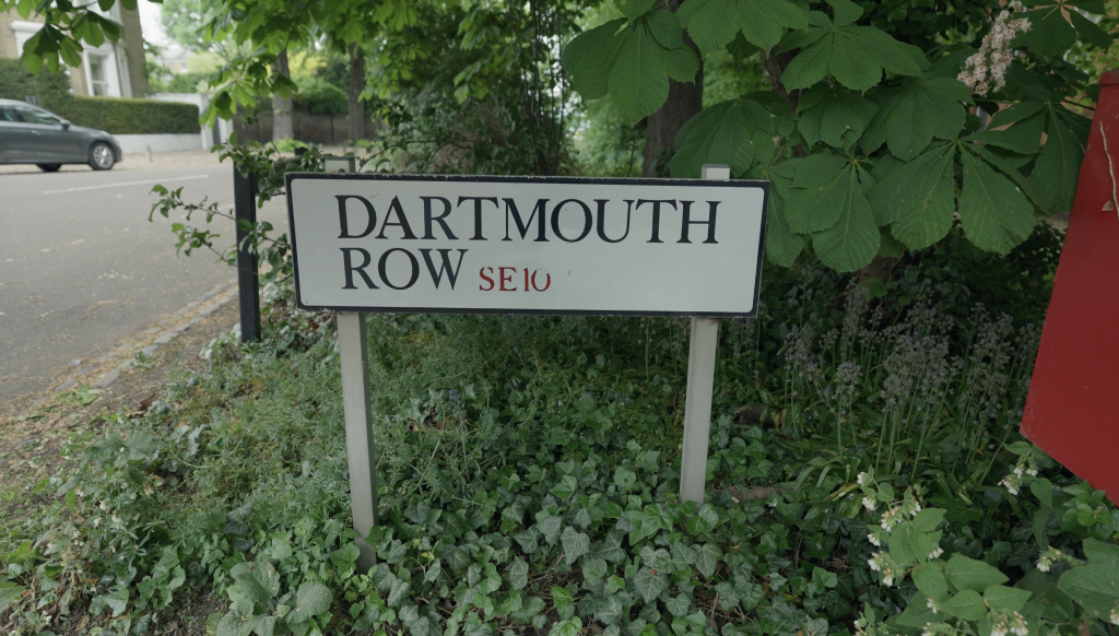 Road sign reads "Dartmouth Row SE10". It is set into nicely styled greenery.