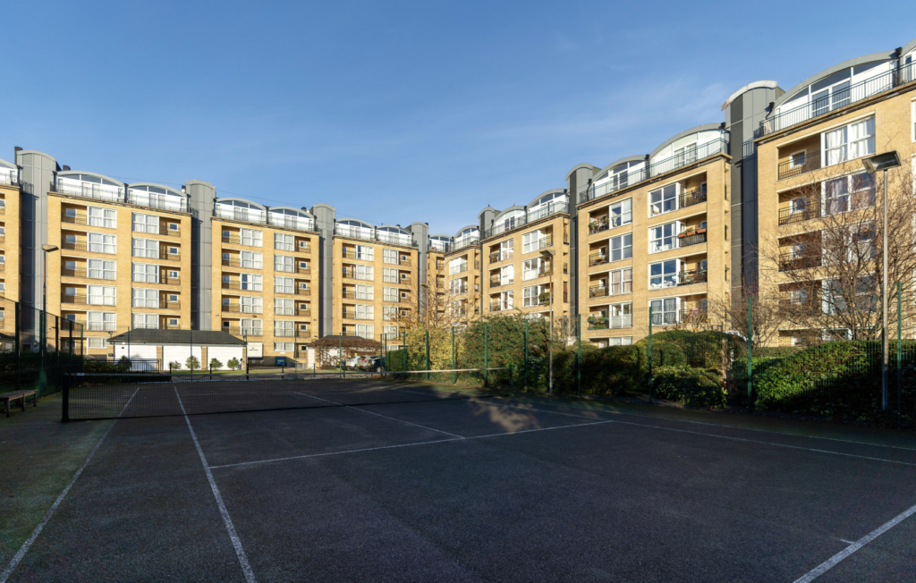 Blocks of flats line the development's communal tennis courts